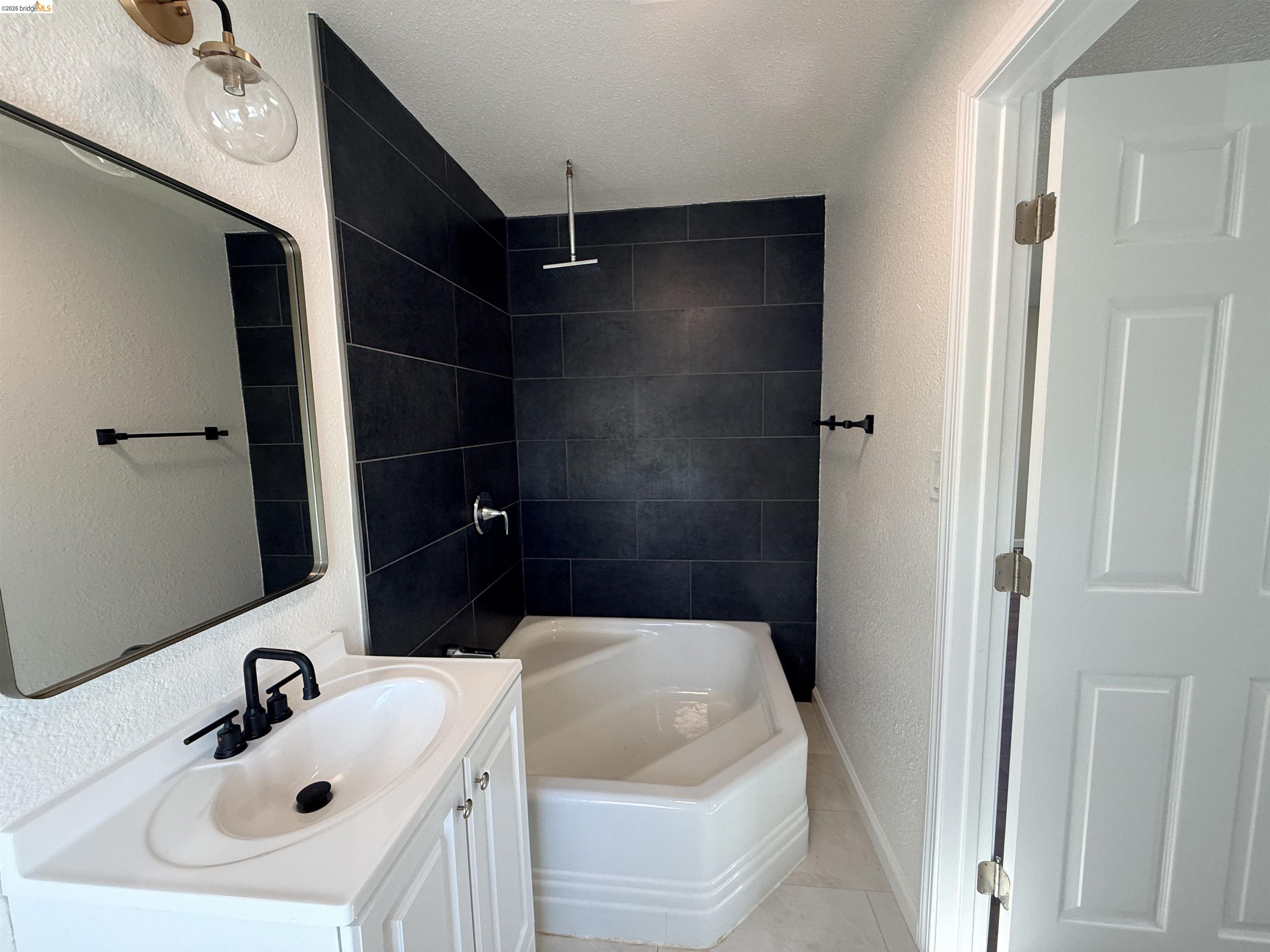 321 Benicia Road Vallejo, CA 94590 - Photo 20 of 48 Full bath featuring a textured wall, vanity, a combined bath / shower with rainfall shower, and a textured ceiling