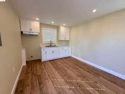 a view of a room with wooden floor and a window