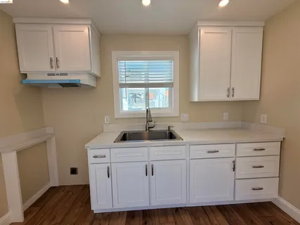a kitchen with granite countertop a sink and cabinets
