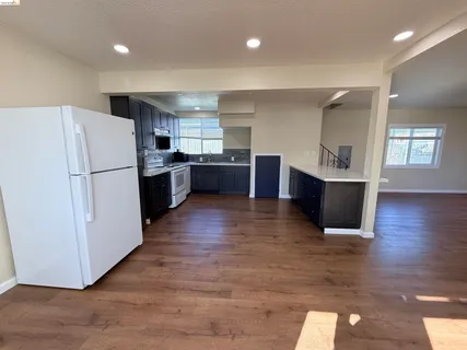 a kitchen with a refrigerator and a stove top oven
