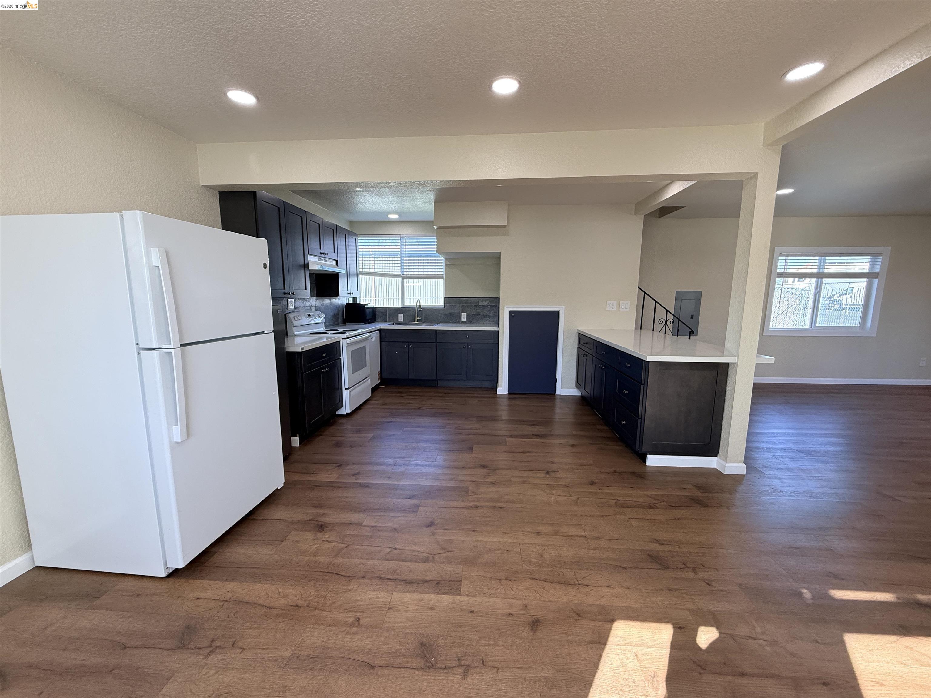 321 Benicia Road Vallejo, CA 94590 - Photo 7 of 48 Kitchen with white appliances, light countertops, dark wood-type flooring, recessed lighting, and a textured ceiling