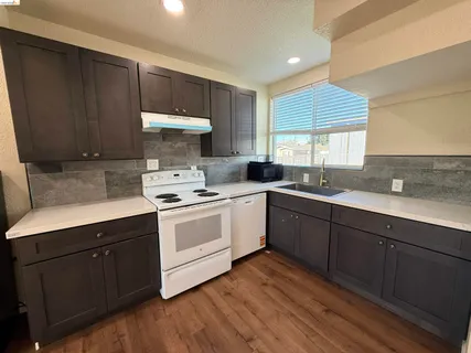 a kitchen with a sink cabinets and window