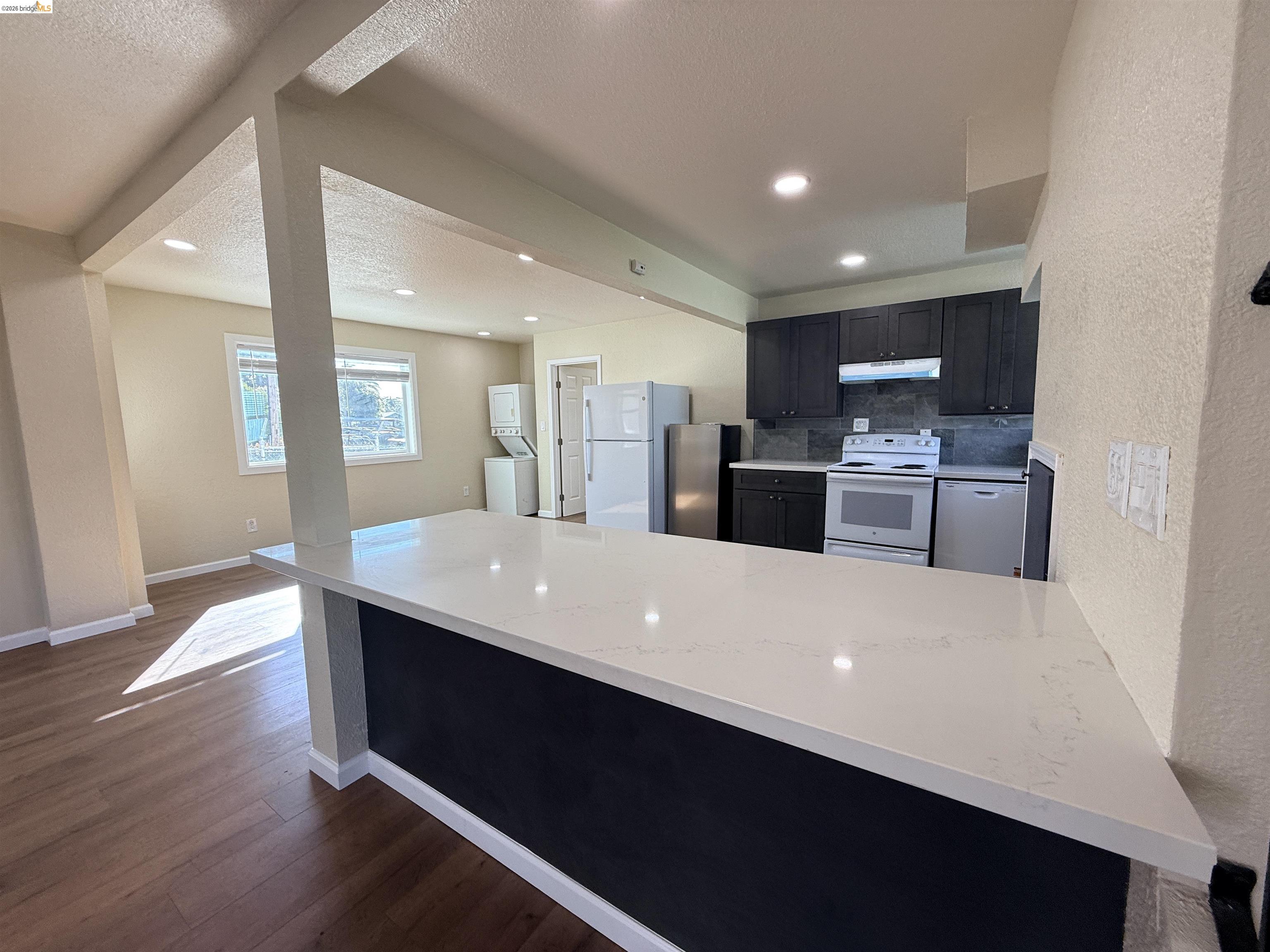 321 Benicia Road Vallejo, CA 94590 - Photo 9 of 48 Kitchen with a peninsula, white appliances, dark cabinetry, backsplash, and dark wood-style flooring