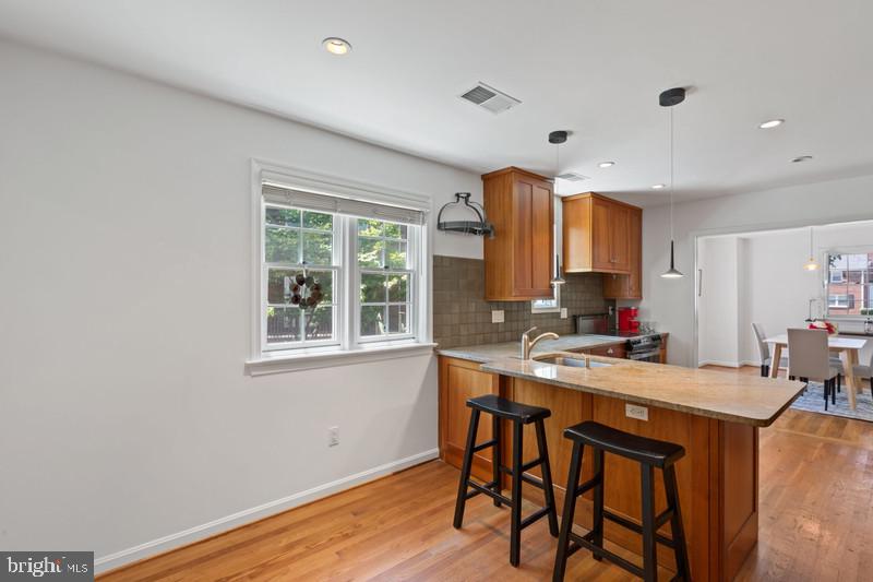 6701 Fairfax Road, Unit 76 Chevy Chase, MD 20815 - Photo 12 of 42 a kitchen with a table chairs refrigerator and window
