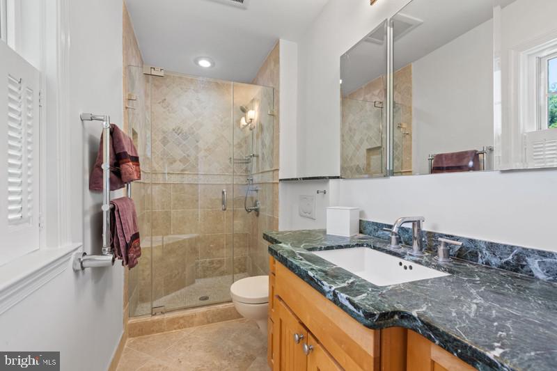 6701 Fairfax Road, Unit 76 Chevy Chase, MD 20815 - Photo 21 of 42 a bathroom with a granite countertop sink toilet and shower