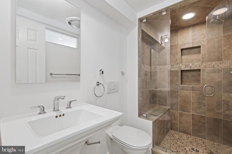 6701 Fairfax Road, Unit 76 Chevy Chase, MD 20815 - Photo 33 of 42 a bathroom with a sink toilet and shower