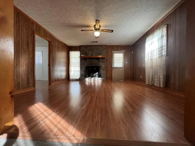 a view of a livingroom with wooden floor and a ceiling fan
