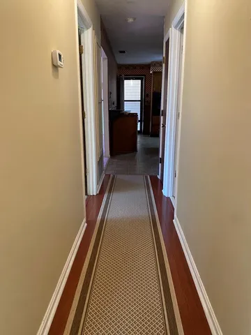 a view of a hallway with wooden floor and a balcony