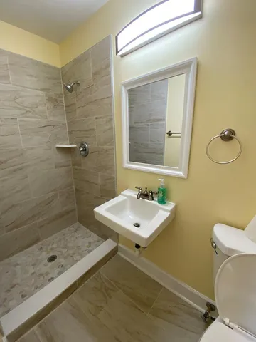 a bathroom with a sink a toilet and shower