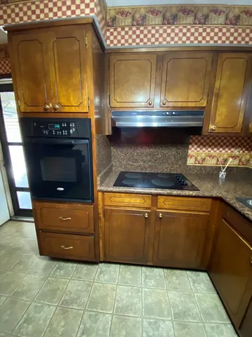a kitchen with granite countertop a stove a sink and a microwave