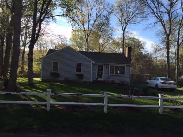 a view of a house with backyard and trees