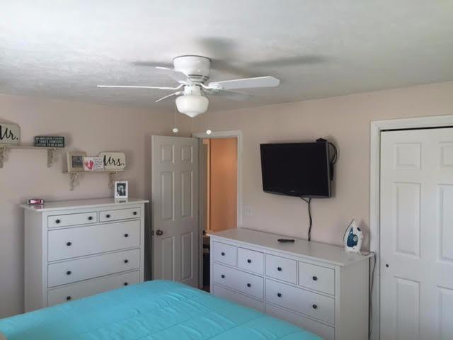 64 Edgewater Road Mashpee, MA 02649 - Photo 16 of 18 a bedroom with a bed and a flat tv screen on the dresser