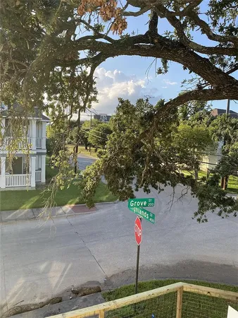 an empty room with wooden floor kitchen view and a window