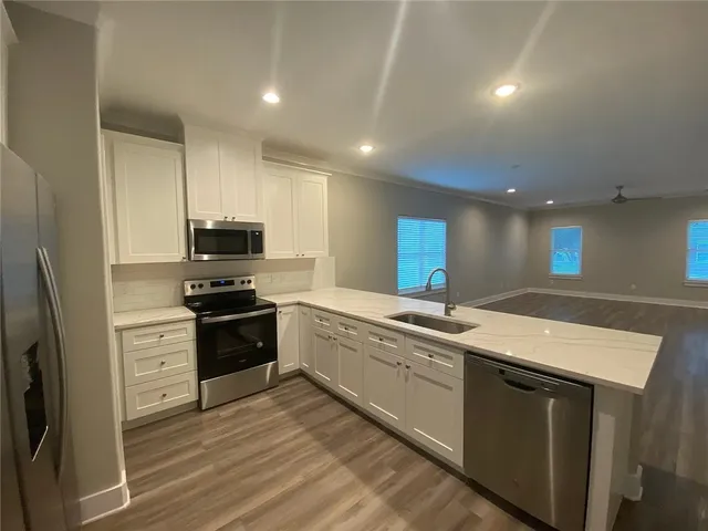a kitchen with stainless steel appliances a refrigerator sink and microwave