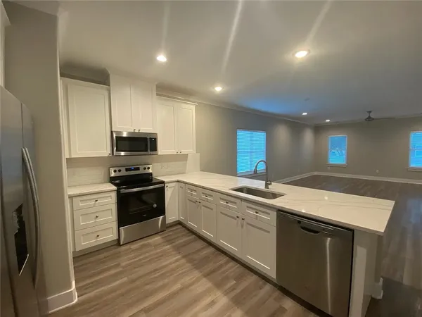 a kitchen with stainless steel appliances a refrigerator sink and microwave