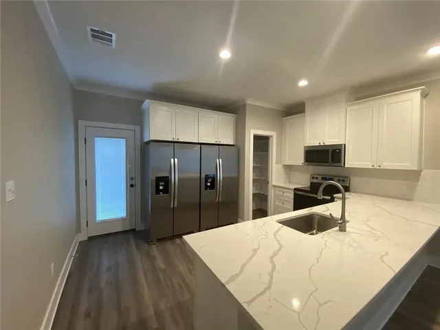 a large kitchen with granite countertop a large counter top and sink