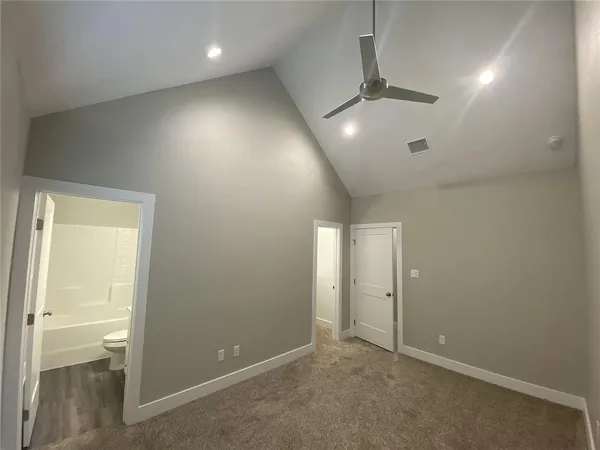 en empty room with closet and a chandelier fan