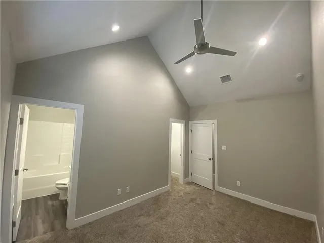 en empty room with closet and a chandelier fan