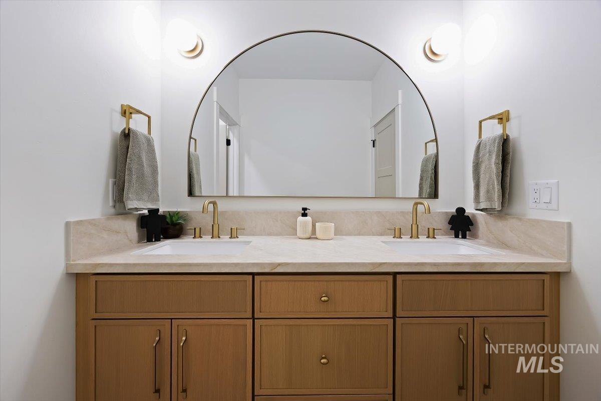 2005 Sparrow Street Rupert, ID 83350 - Photo 24 of 30 Dual vanity with undermount sinks, light-toned countertop, and brass-finish fixtures