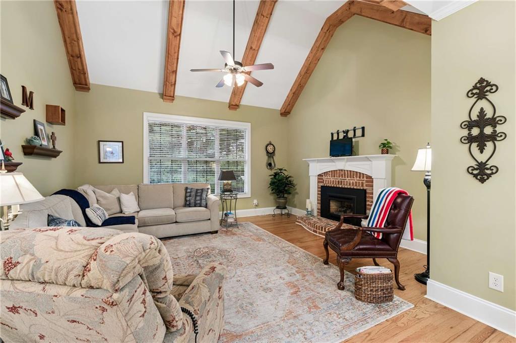 5148 Stefan Ridge Way Buford, GA 30519 - Photo 16 of 39 a living room with furniture a fireplace and a floor to ceiling window