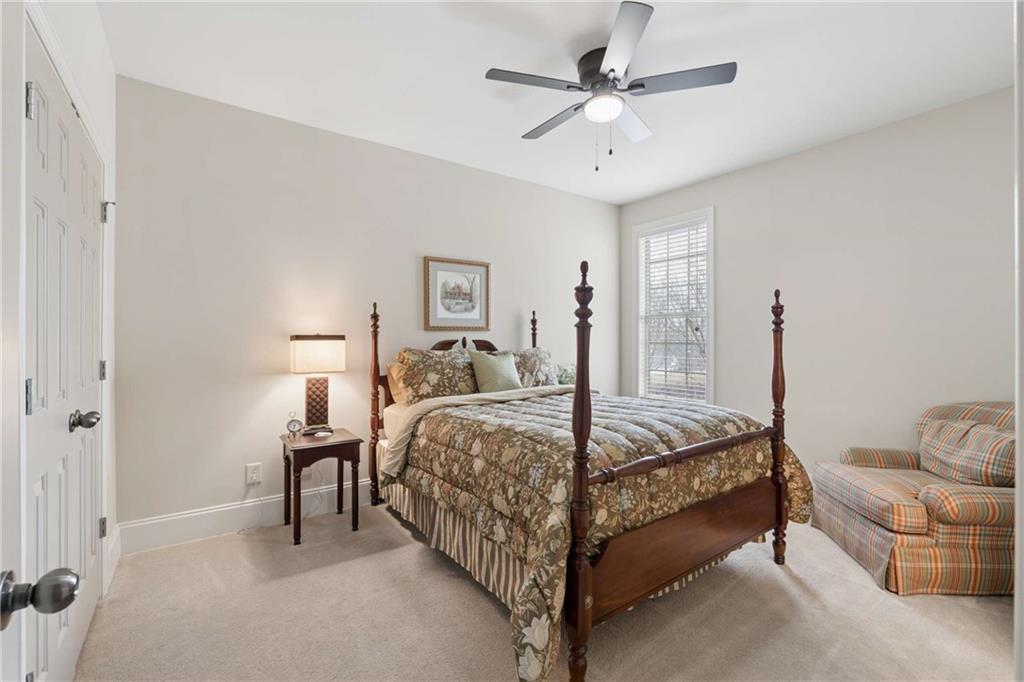 5148 Stefan Ridge Way Buford, GA 30519 - Photo 24 of 39 a bedroom with a bed and a chandelier