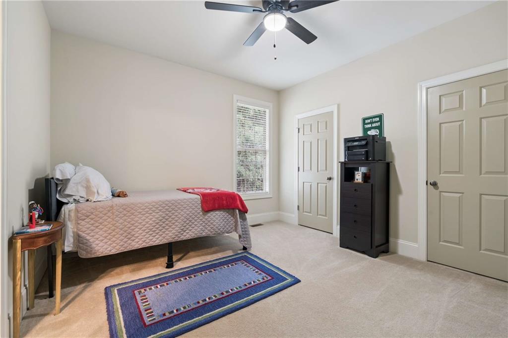 5148 Stefan Ridge Way Buford, GA 30519 - Photo 26 of 39 a bedroom with furniture and a chandelier