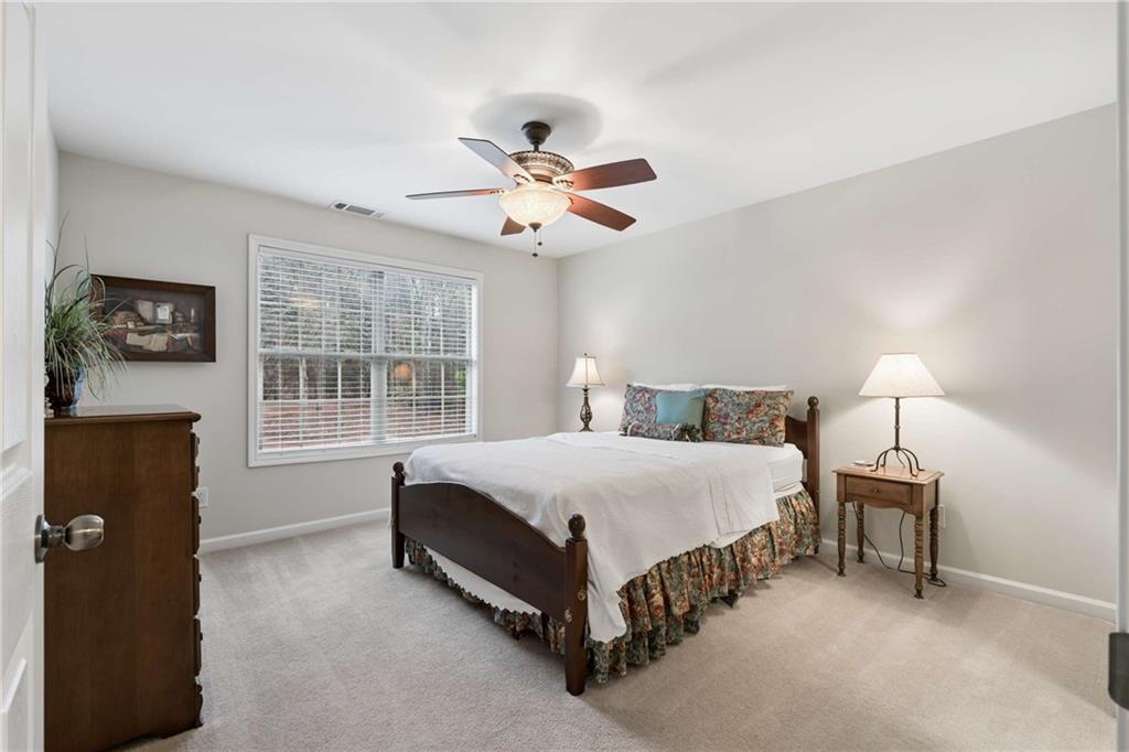 5148 Stefan Ridge Way Buford, GA 30519 - Photo 29 of 39 a spacious bedroom with a bed and a table in it