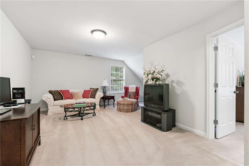5148 Stefan Ridge Way Buford, GA 30519 - Photo 30 of 39 a living room with furniture and a flat screen tv