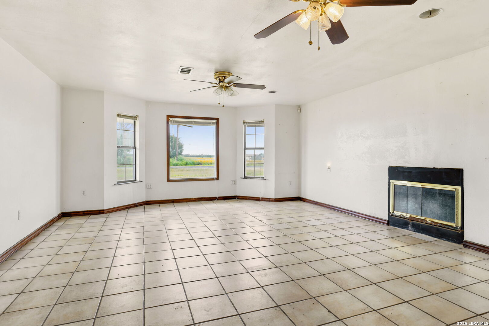 3061 Horse Ranch Road San Antonio, TX 78264 - Photo 4 of 34 a view of an empty room with a fireplace and a chandelier fan
