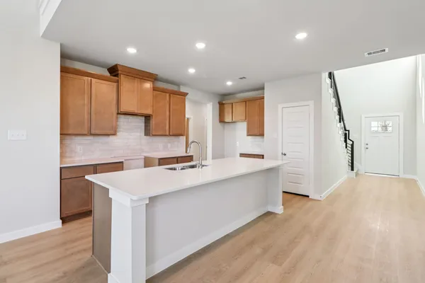 a large kitchen with stainless steel appliances a sink stove and cabinets