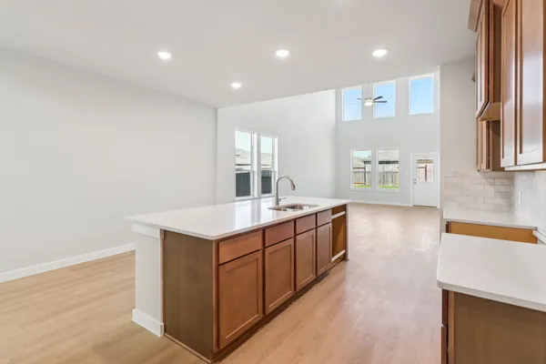 a large kitchen with stainless steel appliances granite countertop a large counter top a sink and a wooden floor