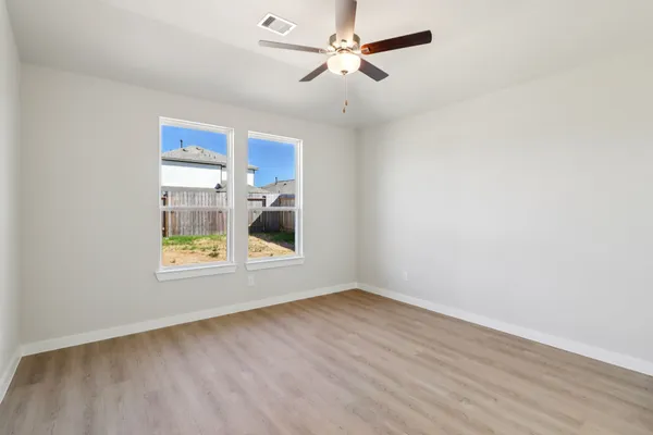 a view of a livingroom with wooden floor and a ceiling fan