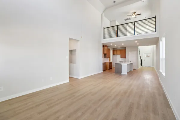 a view of a hallway with wooden floor and a bathroom