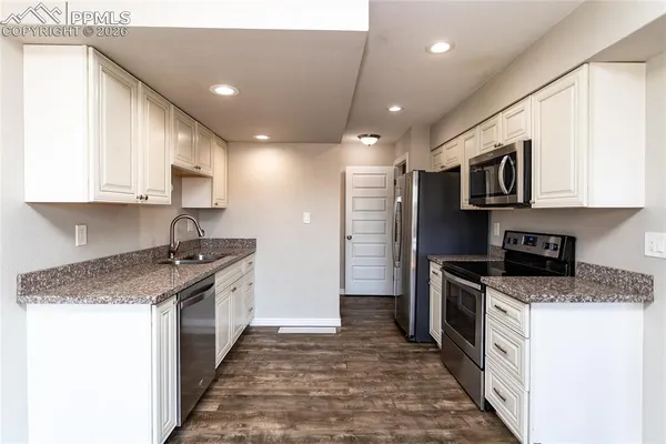a kitchen with stainless steel appliances granite countertop a stove top oven a sink and dishwasher