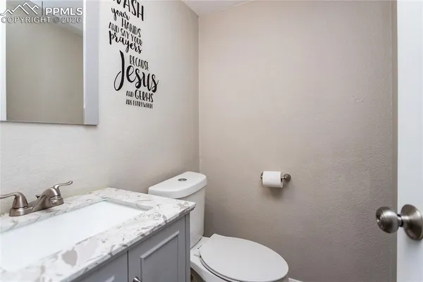 a bathroom with a granite countertop sink and a toilet