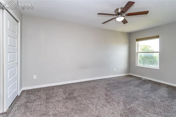an empty room with a window and a fan