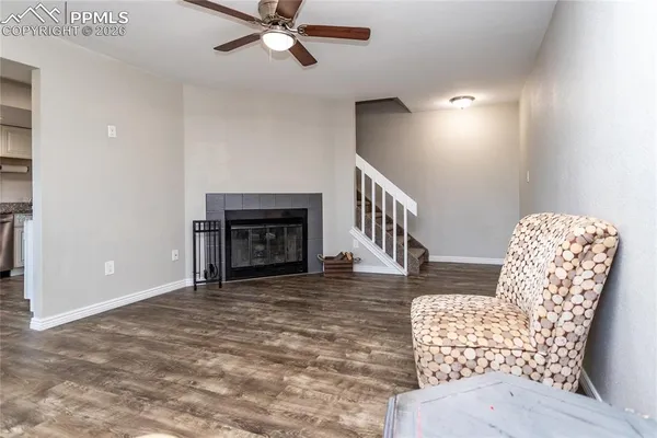 a view of a livingroom with wooden floor and a fireplace