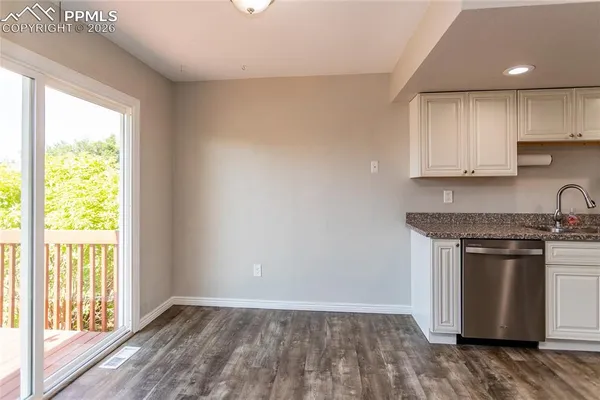 a kitchen with granite countertop wooden floors and stainless steel appliances