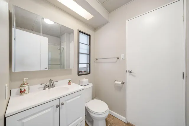 a bathroom with a sink toilet vanity and shower