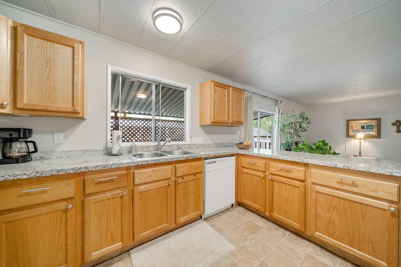 450 Gladycon Road, Unit 52 Colfax, CA 95713 - Photo 9 of 29 a kitchen with granite countertop sink window and cabinets