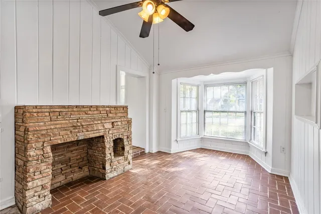 a view of an empty room with window and fire place