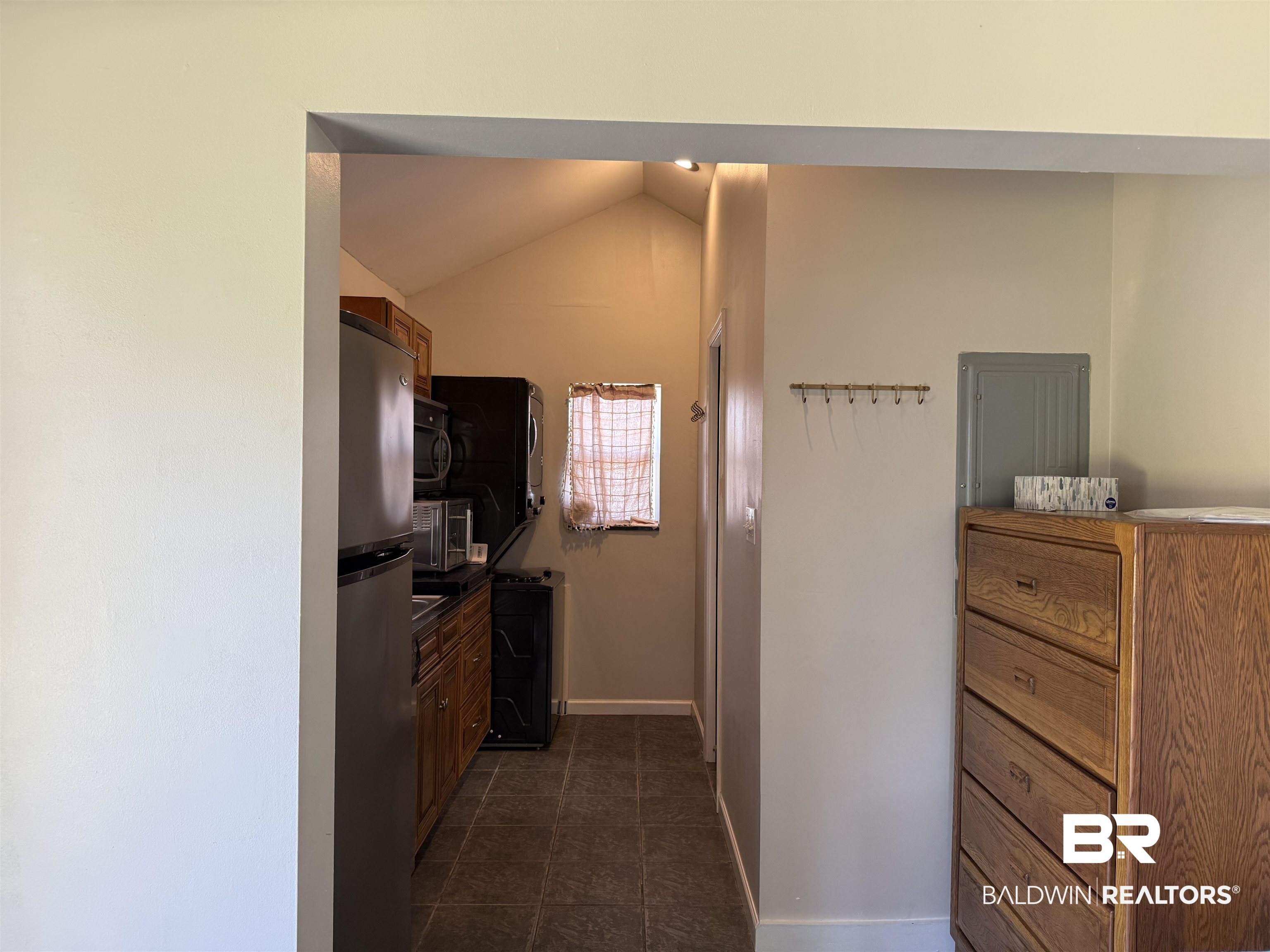 28114 Preserve Trail, Unit 190 Elberta, AL 36530 - Photo 27 of 69 Kitchen featuring stainless steel appliances, lofted ceiling, wood finish cabinets, dark countertops, and dark tile patterned floors