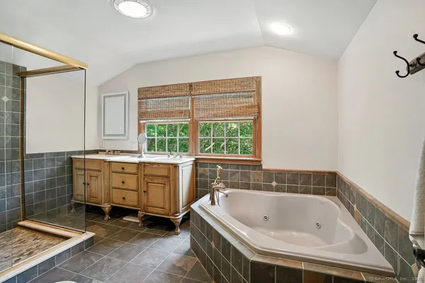 a spacious bathroom with a tub sink and window