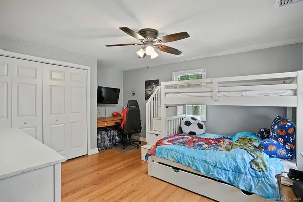 a bedroom with a bed and wooden floor