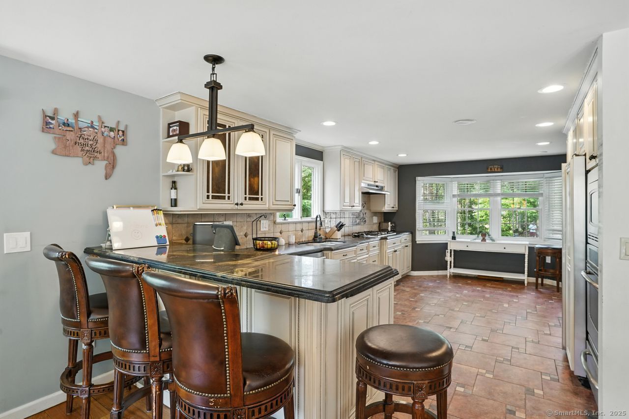 68 Old Dike Road Trumbull, CT 06611 - Photo 8 of 40 a kitchen with kitchen island a dining table chairs and a sink