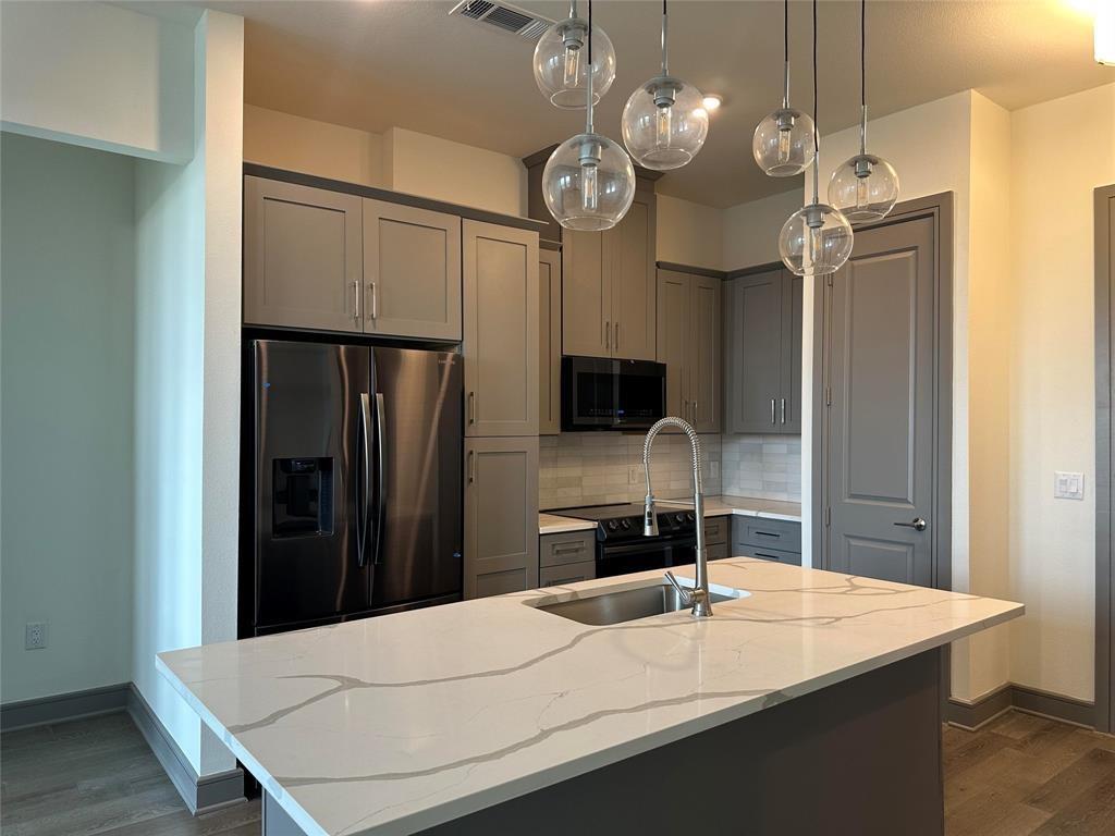2700 Old Denton Road, Unit 4434 Carrollton, TX 75007 - Photo 5 of 13 a kitchen with a table and a refrigerator