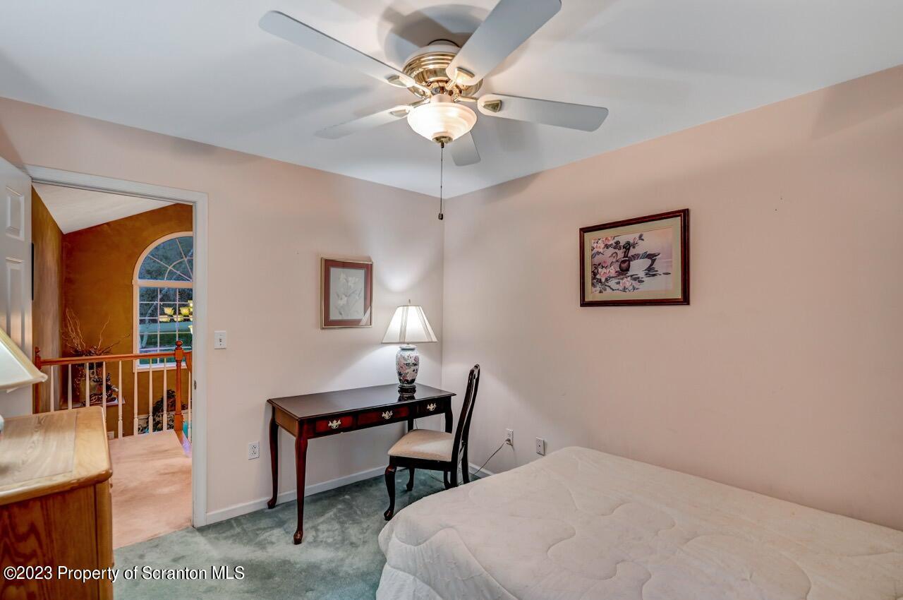 950 Forest Road Lake Ariel, PA 18436 - Photo 54 of 88 a bedroom with a bed and a chandelier