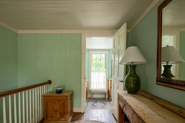 a room with painting on the wall and a window