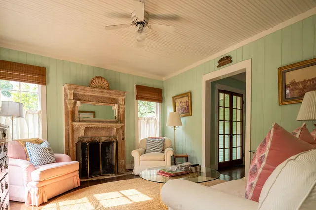 a living room with furniture a fireplace and a large window