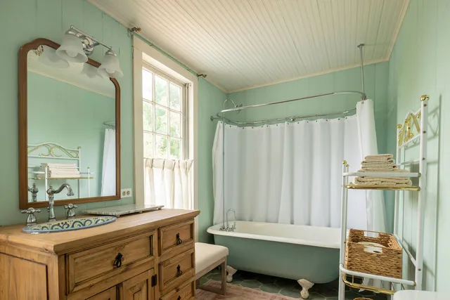a bathroom with a bathtub sink and mirror
